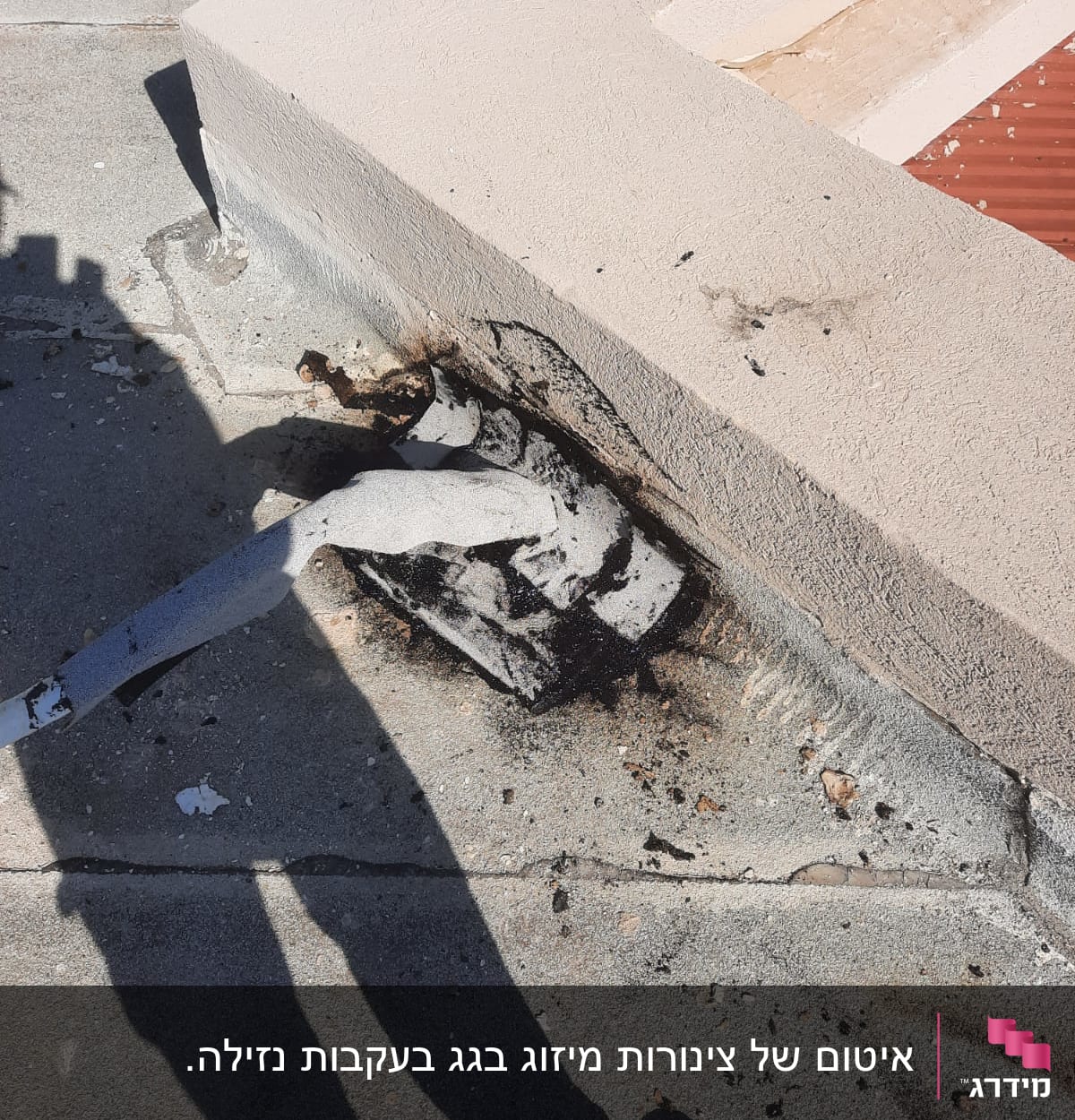 חומר איטום שחור סביב צינור על גג בטון